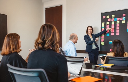 A Bender Insurance Solutions sales meeting, with a leader presenting at a board of coloured notes